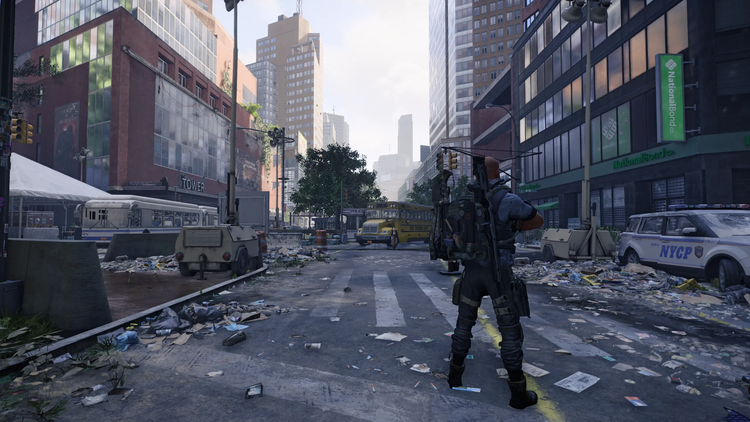 A screenshot from The Division 2 Echoes of Central Park of an Agent standing in the middle of a street in NYC surrounded by chaos, mess, and destruction.