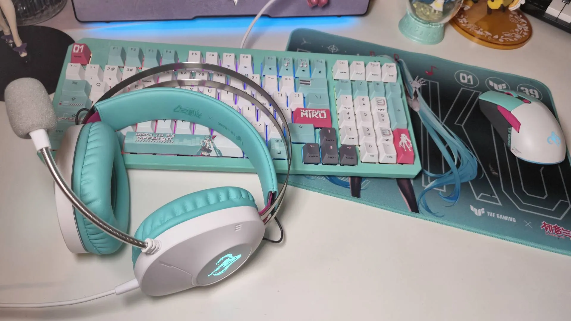 Photo of the Asus TUF Gaming Hatsune Miku collection sitting on a white desk.