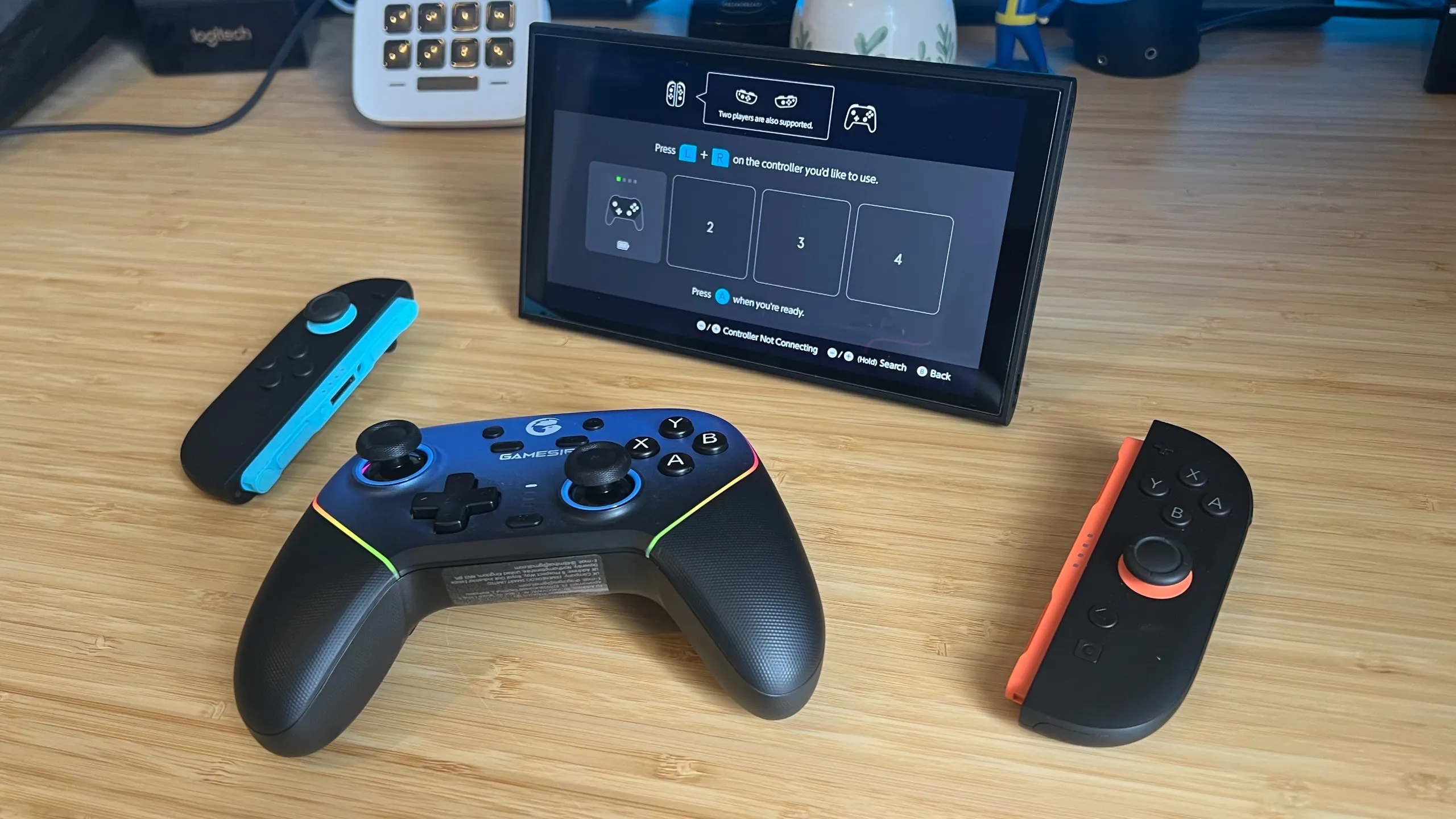 GameSir Super Nova on a wooden desk with Nintendo Switch 2 and two Joy-Con attempting a pairing connection