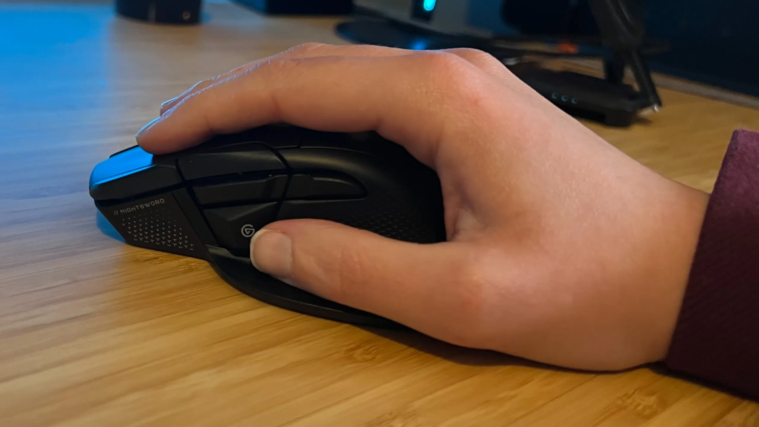 Hand holding the Corsair Nightsword V2 Wireless gaming mouse in a palm grip
