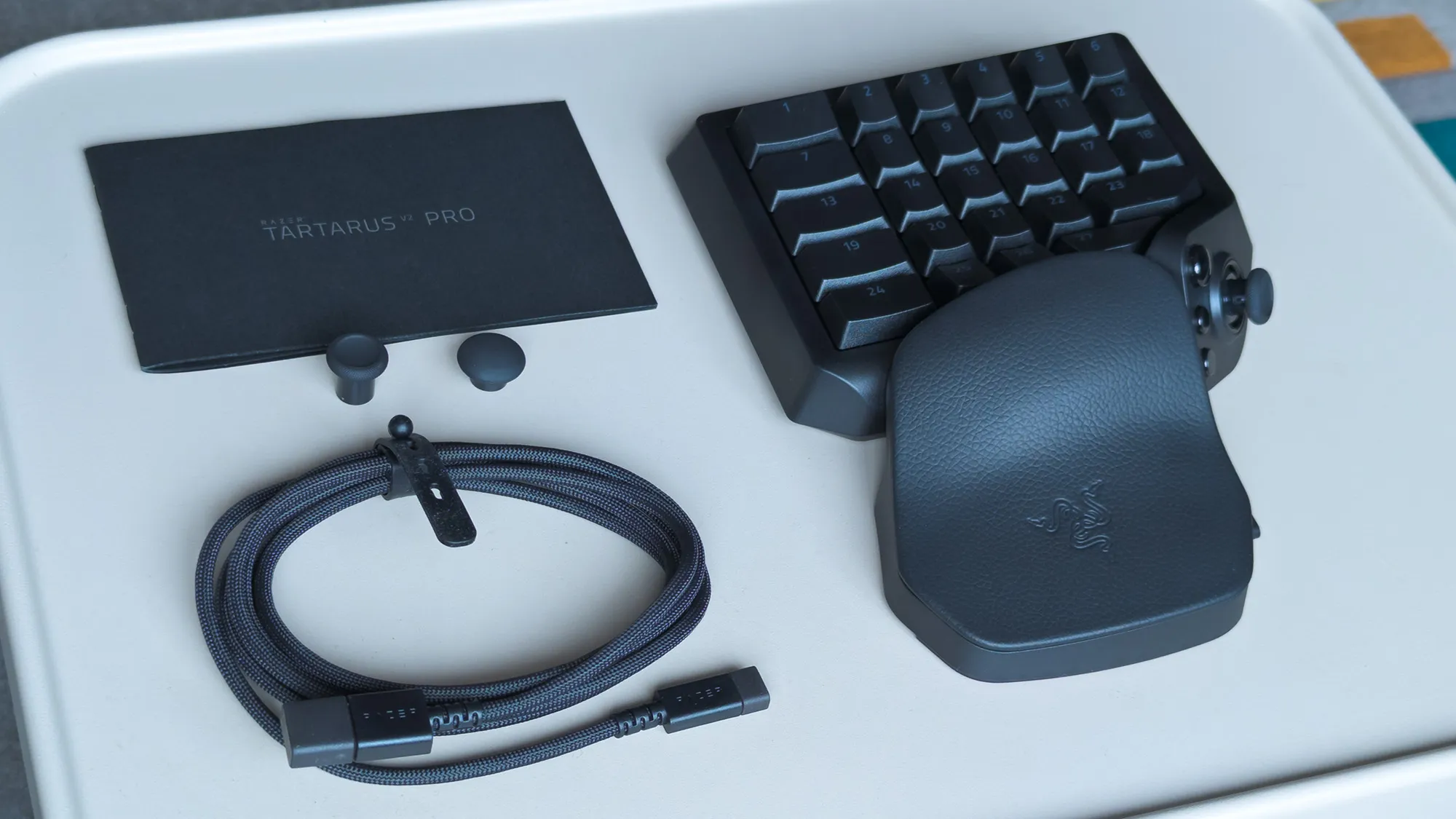 Razer Tartarus V2 Pro box contents displayed on a metal table
