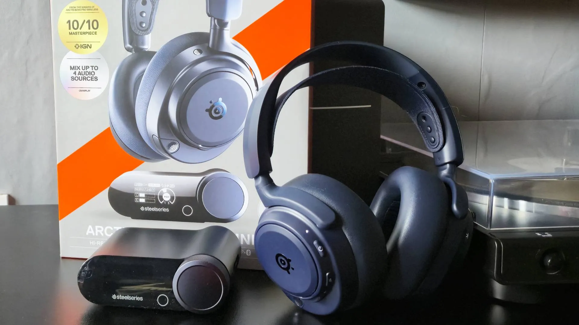 Photo of the Midnight Blue SteelSeries Arctis Nova Pro Omni headset sitting infront of its box.